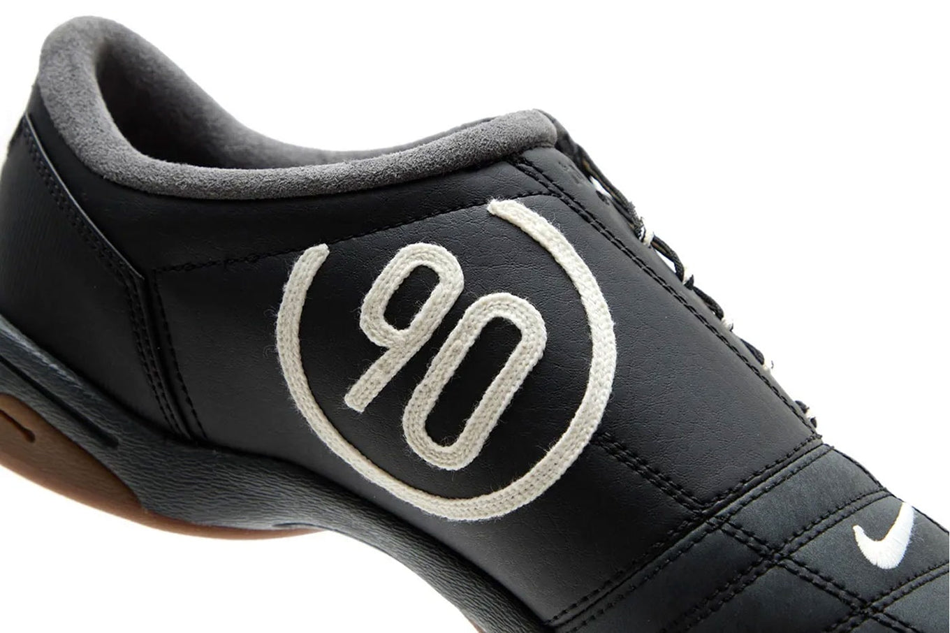 Modern Nike Total 90 with white jacquard upper, black accents, gum sole, and iconic asymmetrical lacing