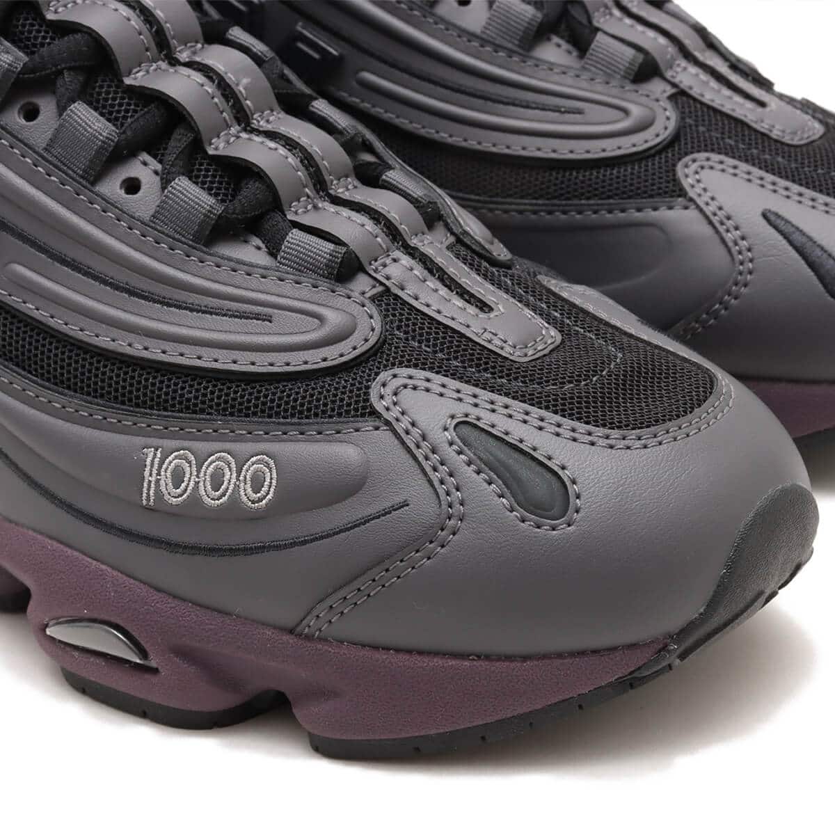 New Balance "Grey Day" inspired grey and black sneaker with plum midsole, leather and mesh construction, and signature "N" logo.