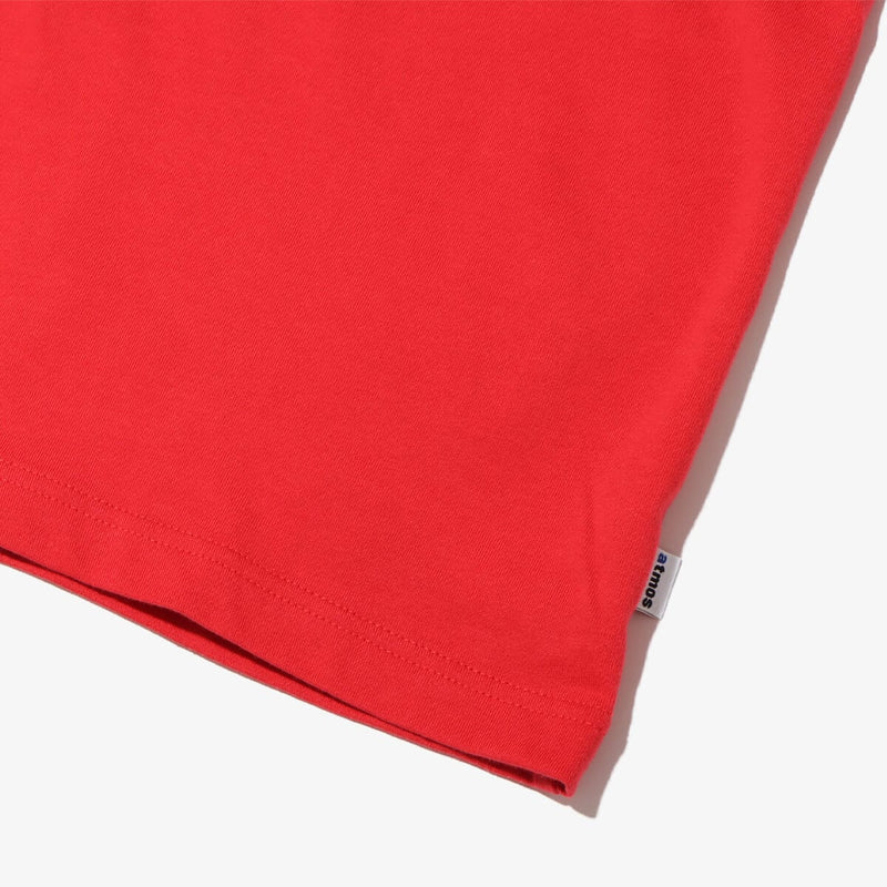 Short-sleeved T-shirt with metallic rubber-printed atmos logo, soft fabric, relaxed fit, and pin name tag on left hem.
