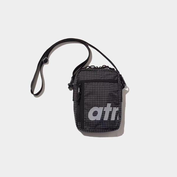 Mini shoulder bag made from durable grid nylon fabric with partition and zipper pockets, featuring a reflective atmos motif for style and nighttime visibility.