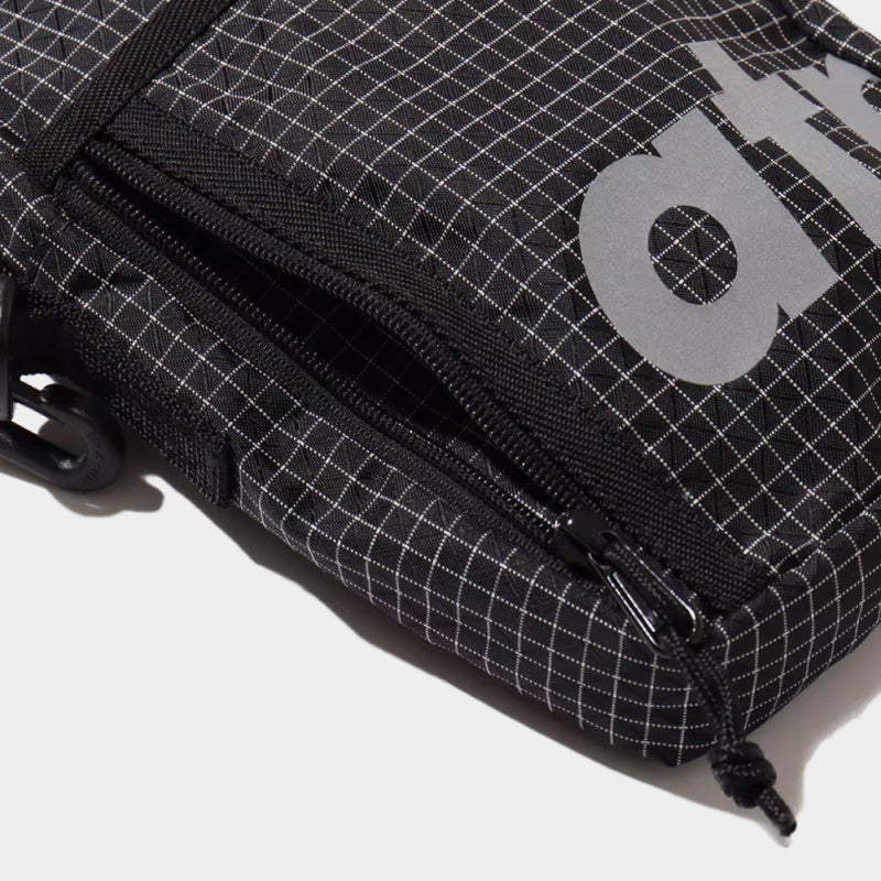 Mini shoulder bag made from durable grid nylon fabric with partition and zipper pockets, featuring a reflective atmos motif for style and nighttime visibility.