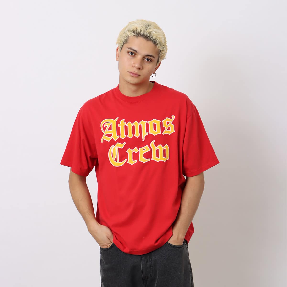 Atmos short-sleeved T-shirt with Old English-style Atmos Crew motif on the front and blue pistag on the left hem, crafted from soft, smooth fabric. Model height 180cm, wearing size L.