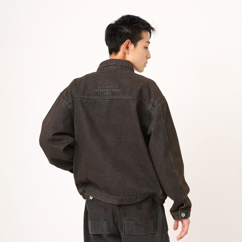 Boxy denim jacket with vintage wash, workwear details, and relaxed fit, styled with cargo pants.