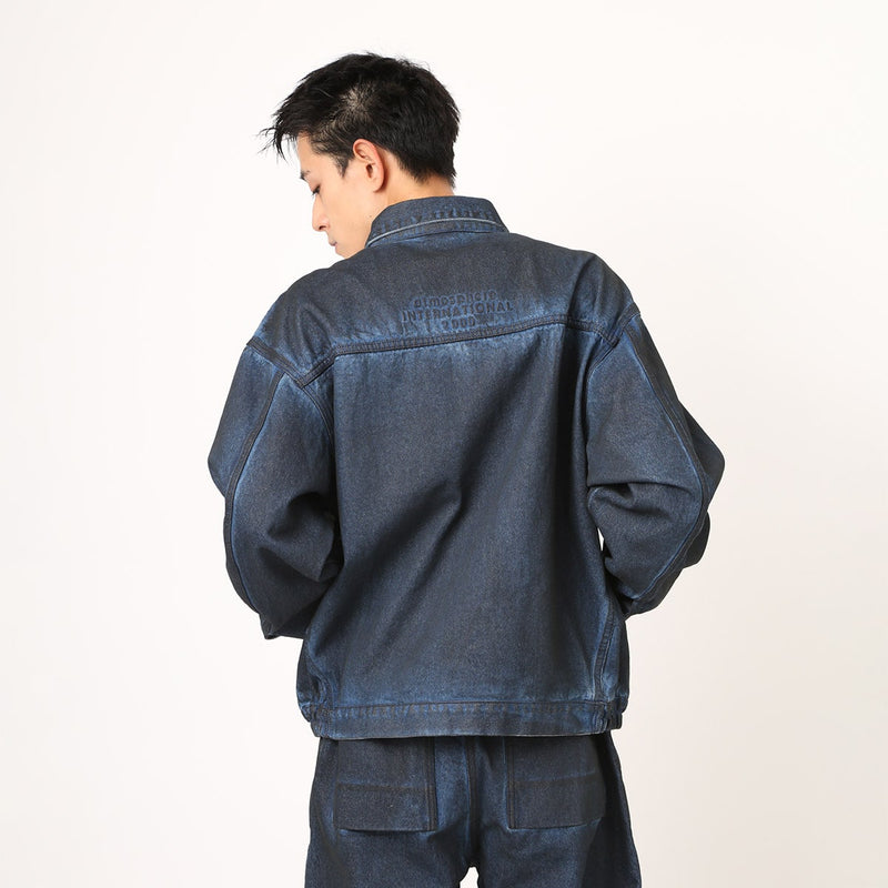 Boxy denim jacket with vintage wash, workwear details, and relaxed fit, styled with cargo pants.