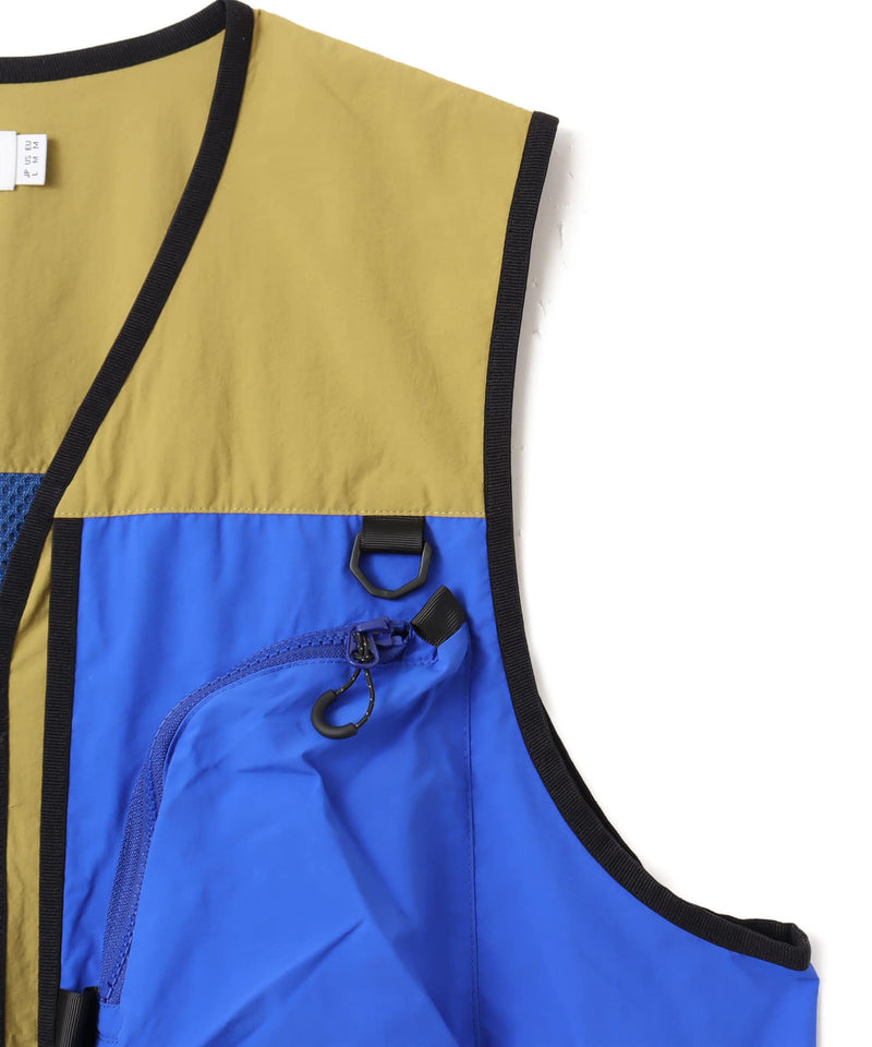 Model wearing a multi-pocket fishing-style vest made from textured nylon with a cotton-like finish.