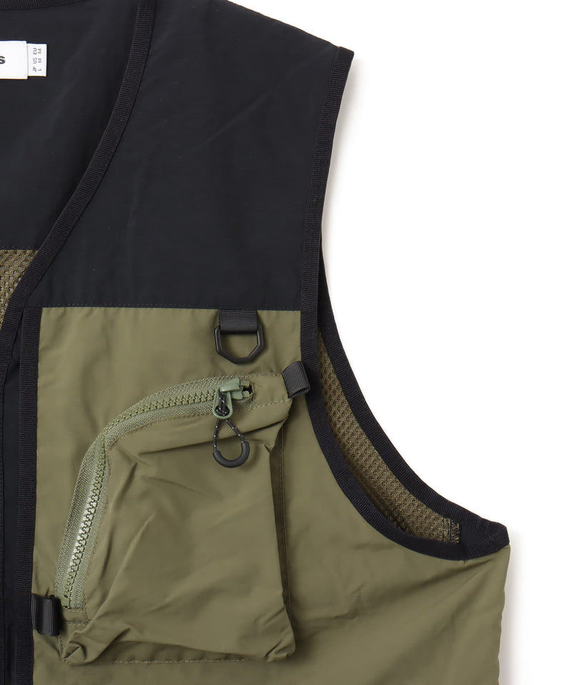 Model wearing a multi-pocket fishing-style vest made from textured nylon with a cotton-like finish.