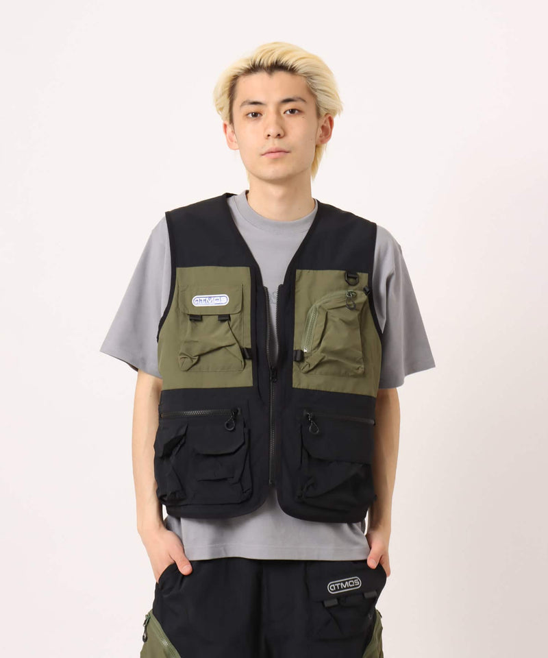 Model wearing a multi-pocket fishing-style vest made from textured nylon with a cotton-like finish.
