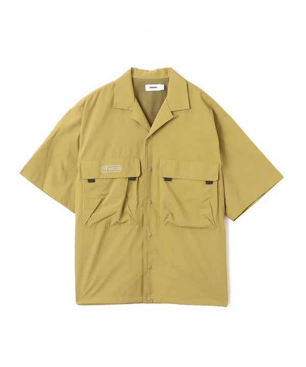 Model wearing a short-sleeved fishing-style nylon shirt with flap pocket and reflective atmos logo.