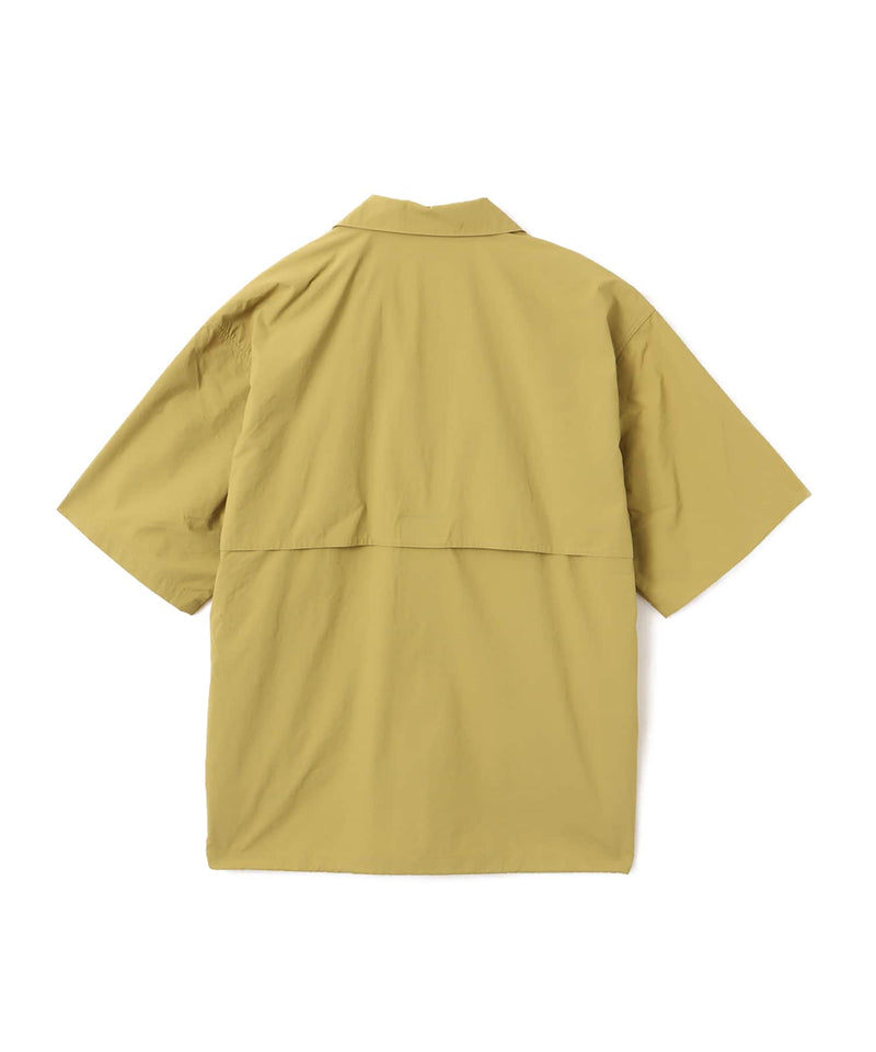 Model wearing a short-sleeved fishing-style nylon shirt with flap pocket and reflective atmos logo.
