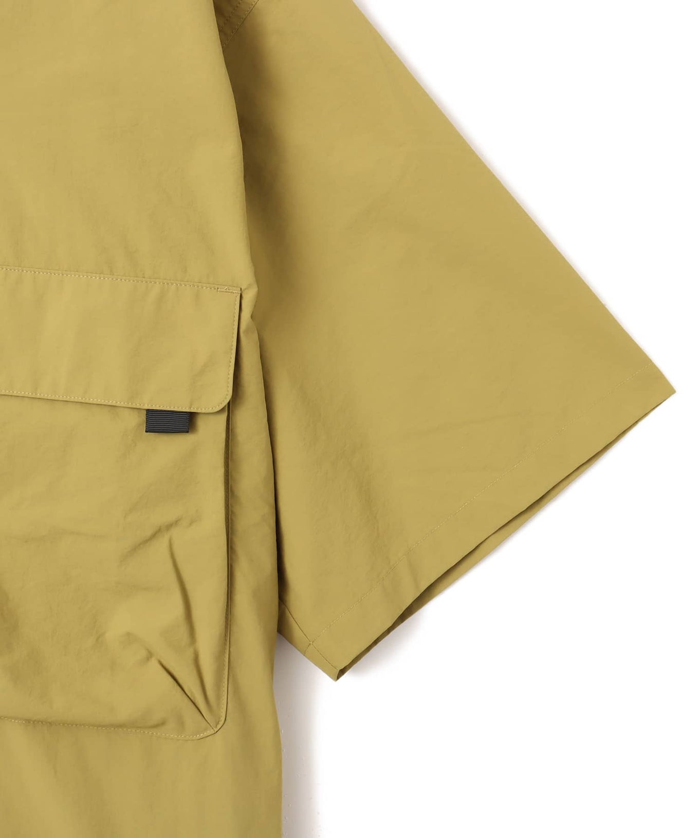 Model wearing a short-sleeved fishing-style nylon shirt with flap pocket and reflective atmos logo.