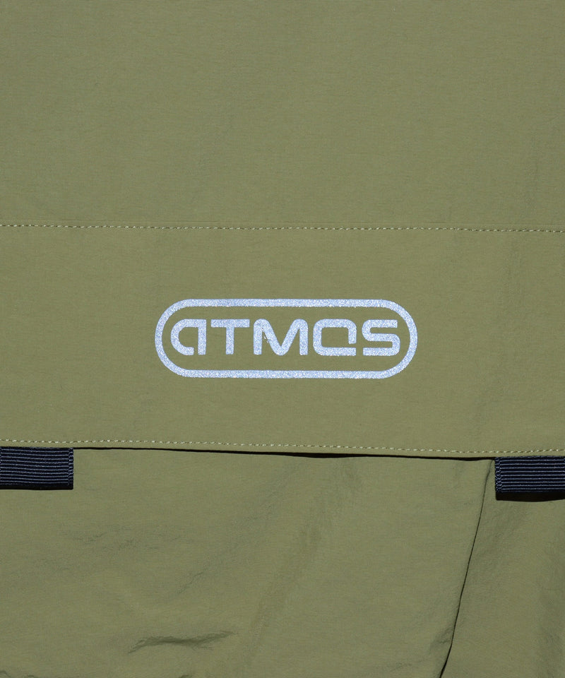 Model wearing a short-sleeved fishing-style nylon shirt with flap pocket and reflective atmos logo.