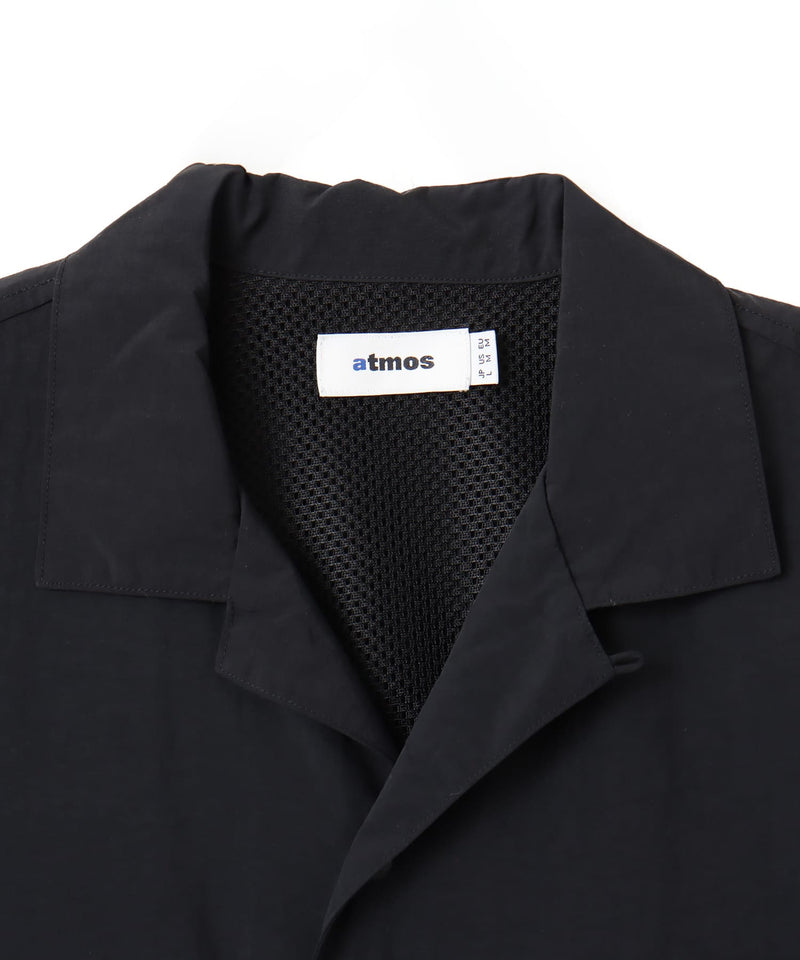 Model wearing a short-sleeved fishing-style nylon shirt with flap pocket and reflective atmos logo.