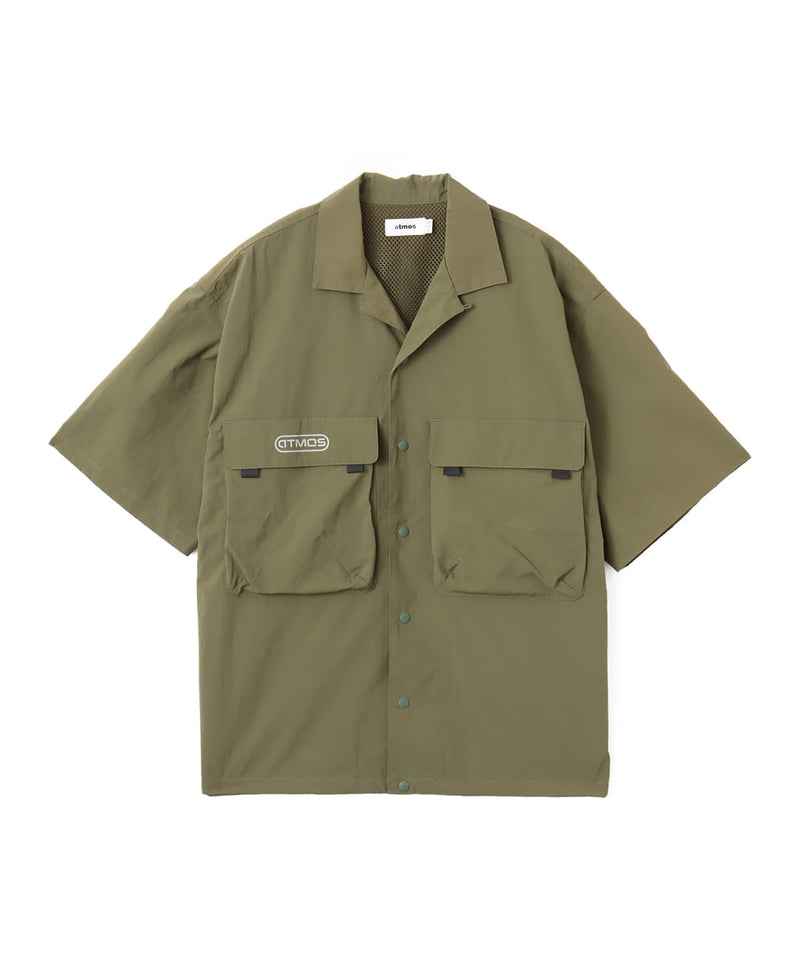 Model wearing a short-sleeved fishing-style nylon shirt with flap pocket and reflective atmos logo.