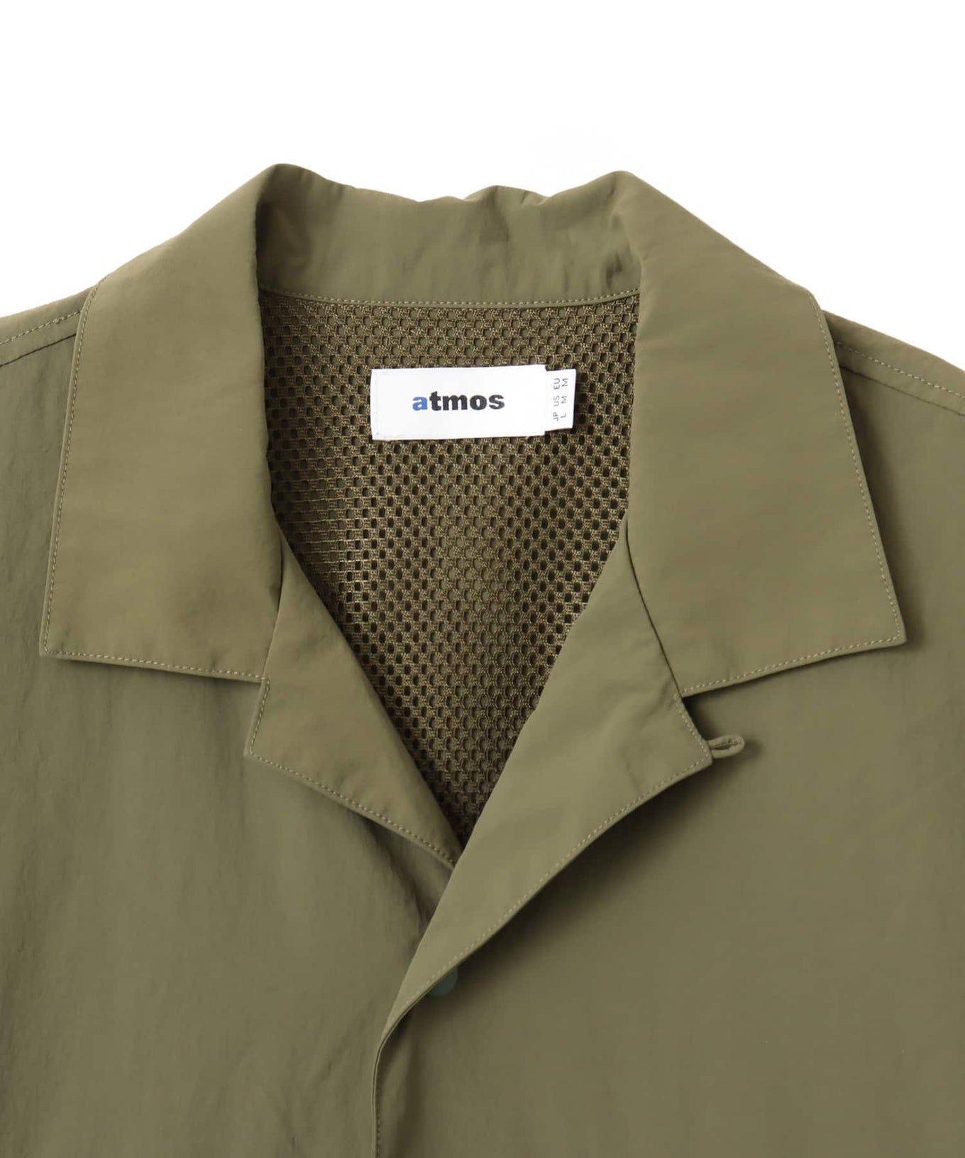 Model wearing a short-sleeved fishing-style nylon shirt with flap pocket and reflective atmos logo.