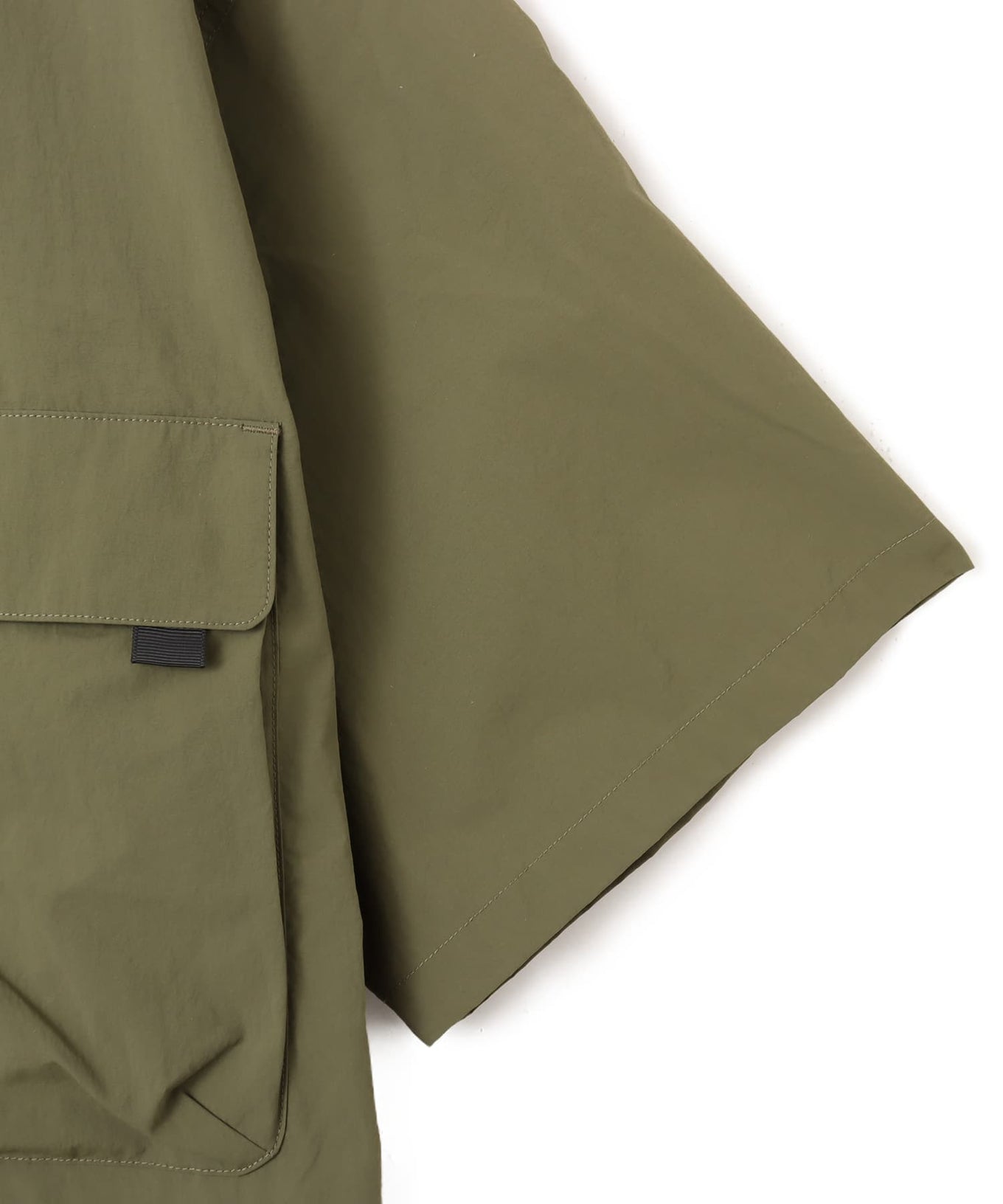 Model wearing a short-sleeved fishing-style nylon shirt with flap pocket and reflective atmos logo.