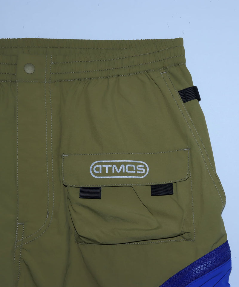 Model wearing functional cargo shorts with mesh and flap pockets in durable cotton fabric.
