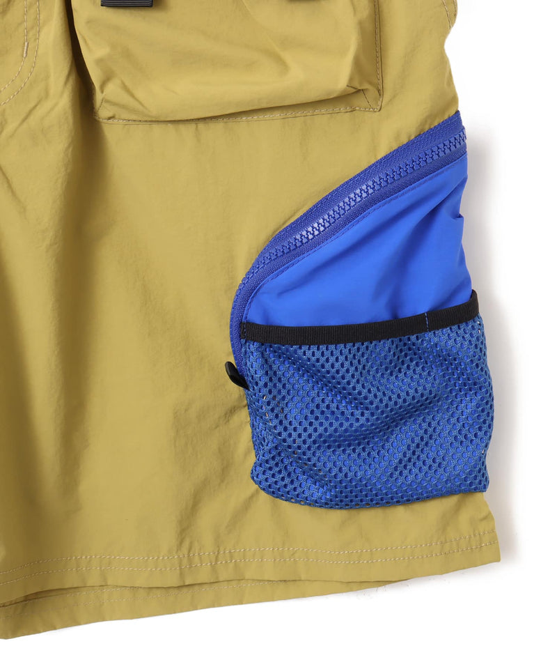 Model wearing functional cargo shorts with mesh and flap pockets in durable cotton fabric.