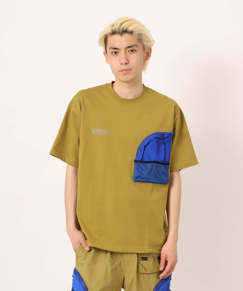 Model wearing a short-sleeved T-shirt with front zip pocket, made from textured, durable cotton.