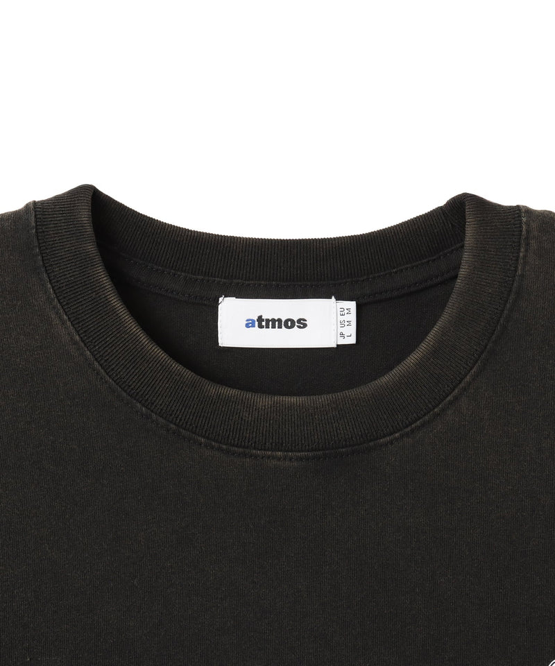 Black atmos T-shirt with Old English logo on front chest and back, styled with a vintage finish and worn by model.