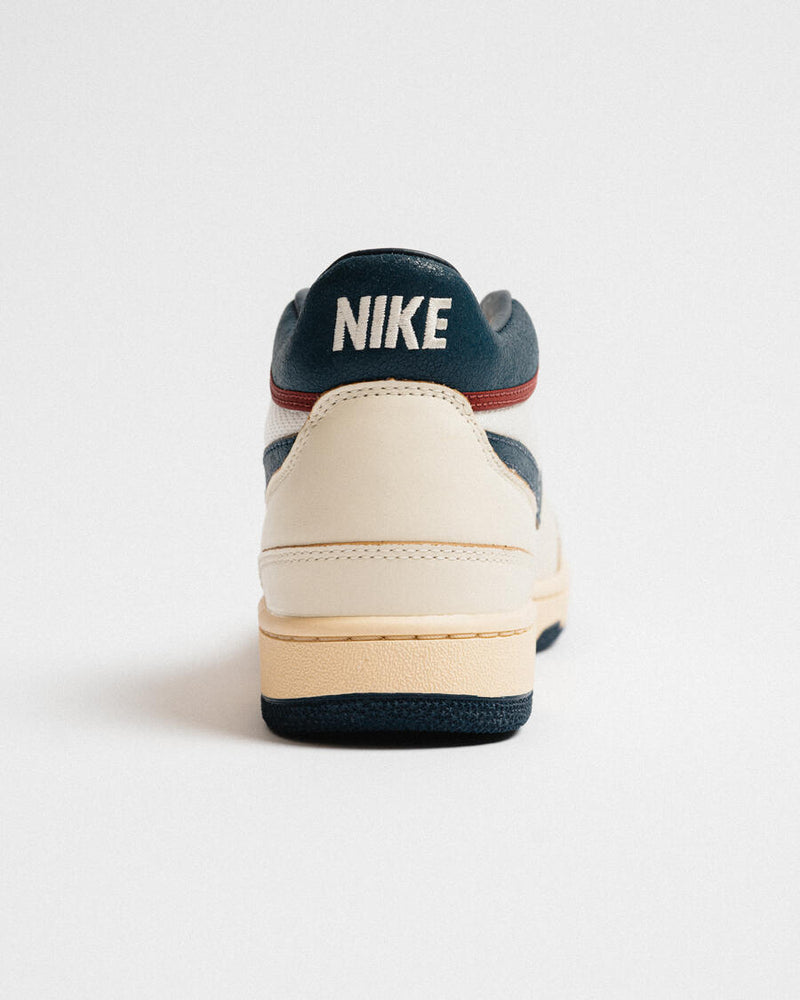 Retro-inspired Sneaker: Coconut Milk Leather with Midnight Navy Accents, Checkered Tongue Label, Painted Midsole