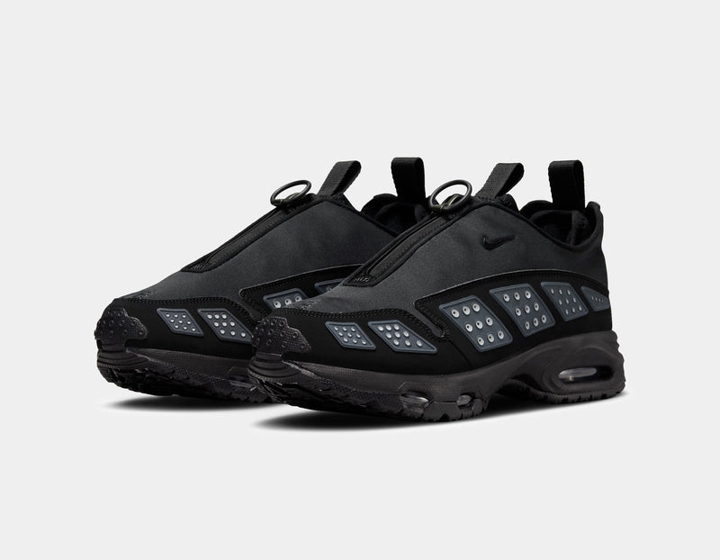 Air Max SNDR sneaker with a bold design featuring Silver accents, a black zip-up shroud, reflective design panels, Max Air cushioning in the heel, and Nike Air in the forefoot. Unzipped shroud reveals ""6453"" representing Nike’s global office numbers.