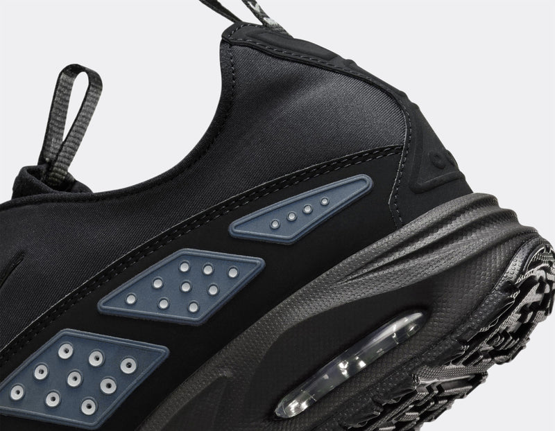 Air Max SNDR sneaker with a bold design featuring Silver accents, a black zip-up shroud, reflective design panels, Max Air cushioning in the heel, and Nike Air in the forefoot. Unzipped shroud reveals ""6453"" representing Nike’s global office numbers.