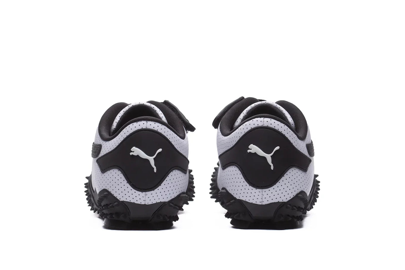 The Puma Mostro features a perforated leather upper, flat silhouette, and iconic Formstrip logo, blending influences from 1960s sprint spikes and 1980s surf shoes.