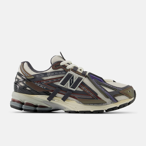 New Balance 1906A sneakers with mesh upper and ABZORB SBS heel cushioning in a retro running silhouette.