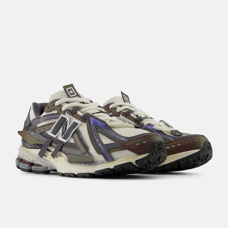New Balance 1906A sneakers with mesh upper and ABZORB SBS heel cushioning in a retro running silhouette.