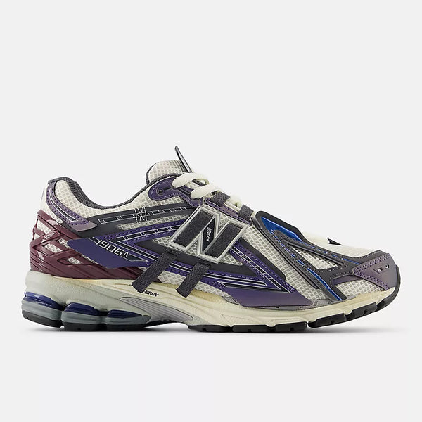 New Balance 1906A sneakers with mesh upper and ABZORB SBS heel cushioning in a retro running silhouette.