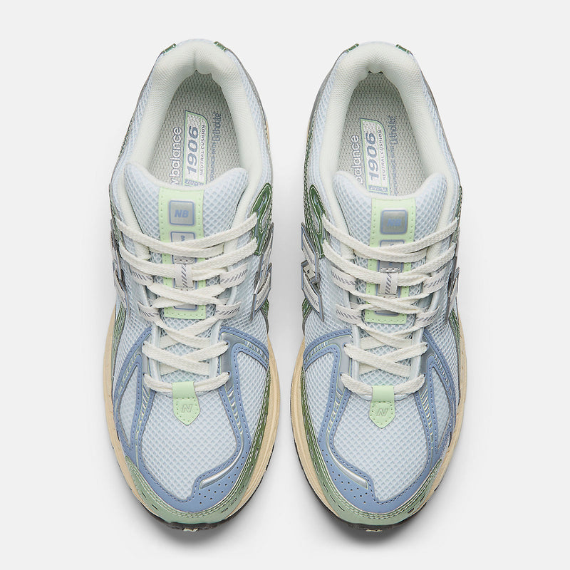 New Balance 1906R sneaker with open-holed mesh upper, curvilinear overlays, and advanced cushioning sole