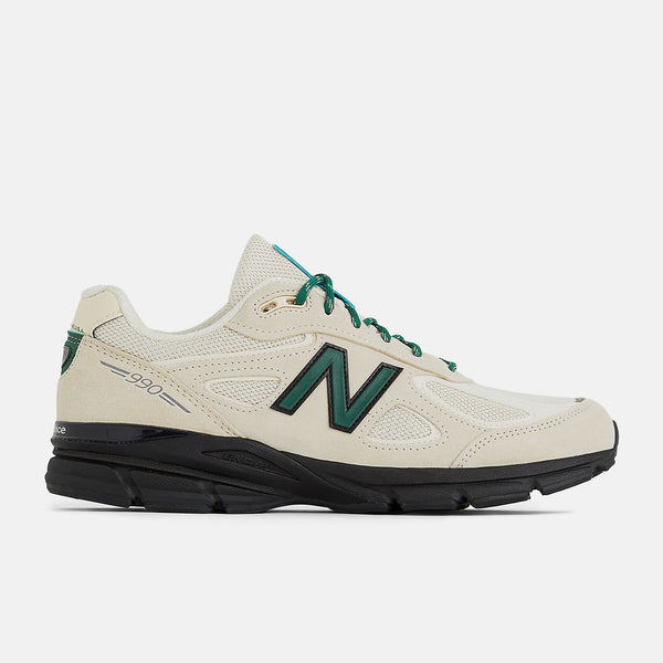 This iconic running shoe showcases the triumphant return of the New Balance 990 v4 after an 8-year hiatus. It features a light beige mesh upper adorned with suede overlays, complemented by black and dark green accents. 