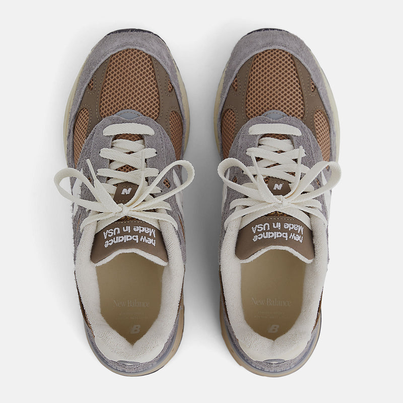 New Balance 993 Made in USA sneakers with driftwood brown mesh upper and shadow grey hairy suede on a dual-colored white and off-white midsole.


