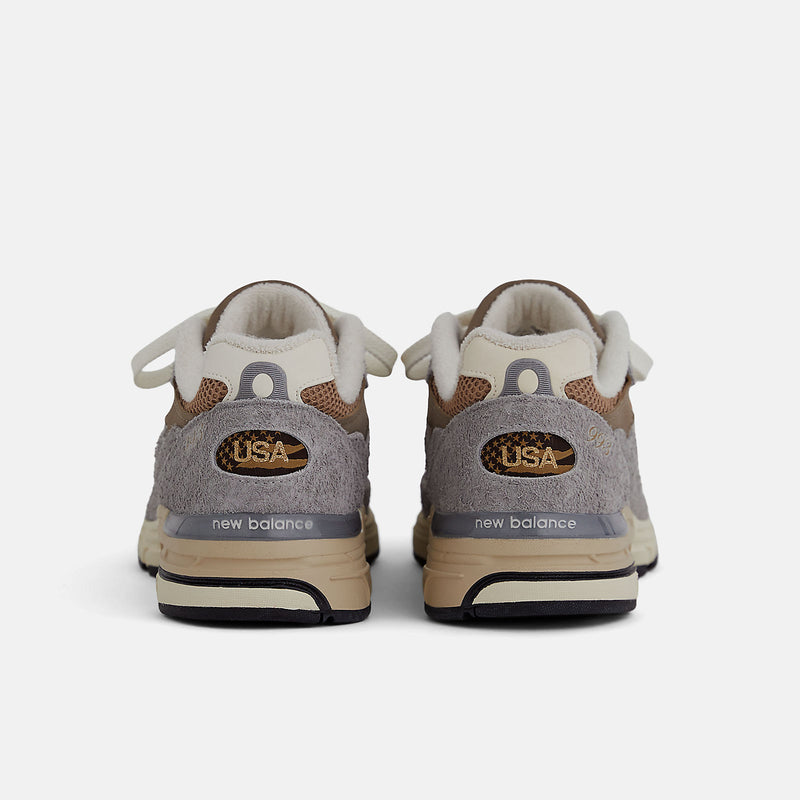 New Balance 993 Made in USA sneakers with driftwood brown mesh upper and shadow grey hairy suede on a dual-colored white and off-white midsole.


