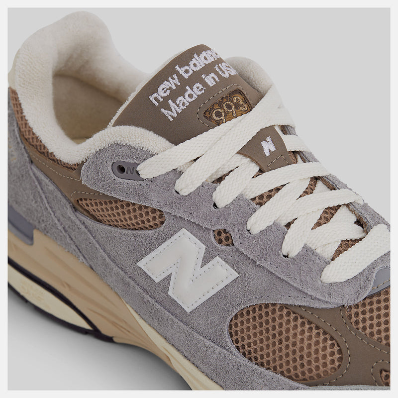 New Balance 993 Made in USA sneakers with driftwood brown mesh upper and shadow grey hairy suede on a dual-colored white and off-white midsole.


