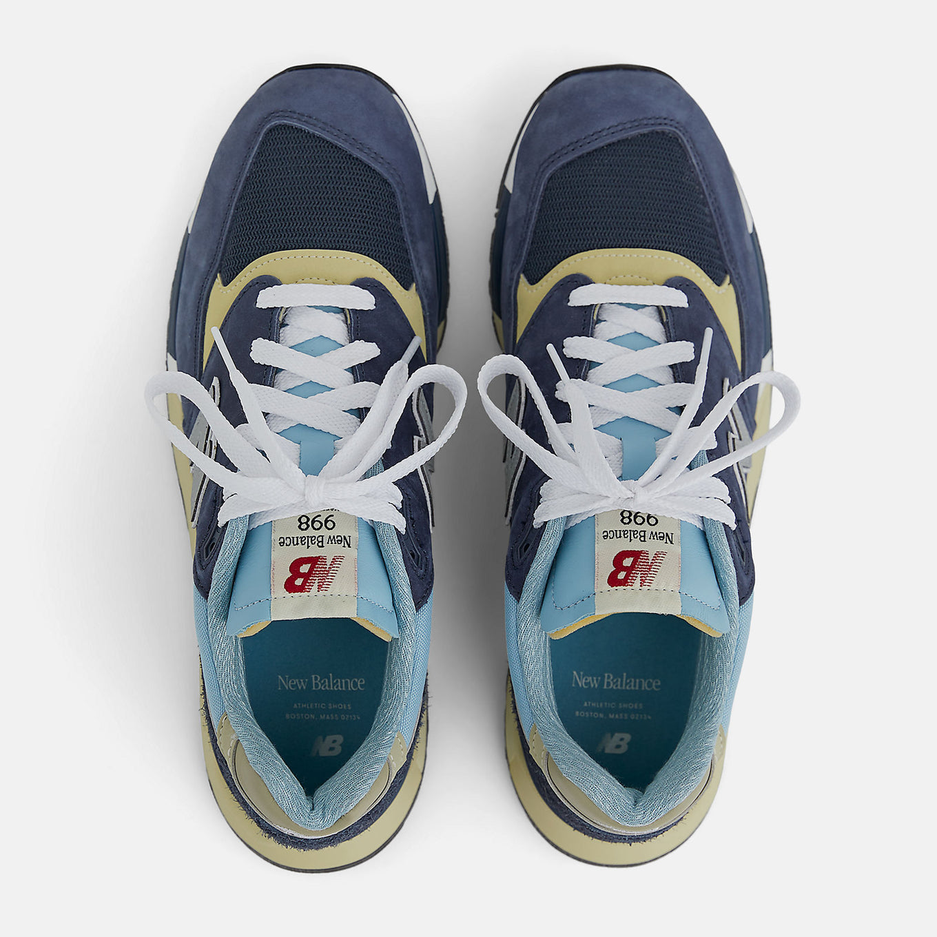 New Balance 998 Made in USA sneakers in navy with chrome blue accents, featuring ABZORB cushioning and premium suede, mesh, and hairy suede construction.
