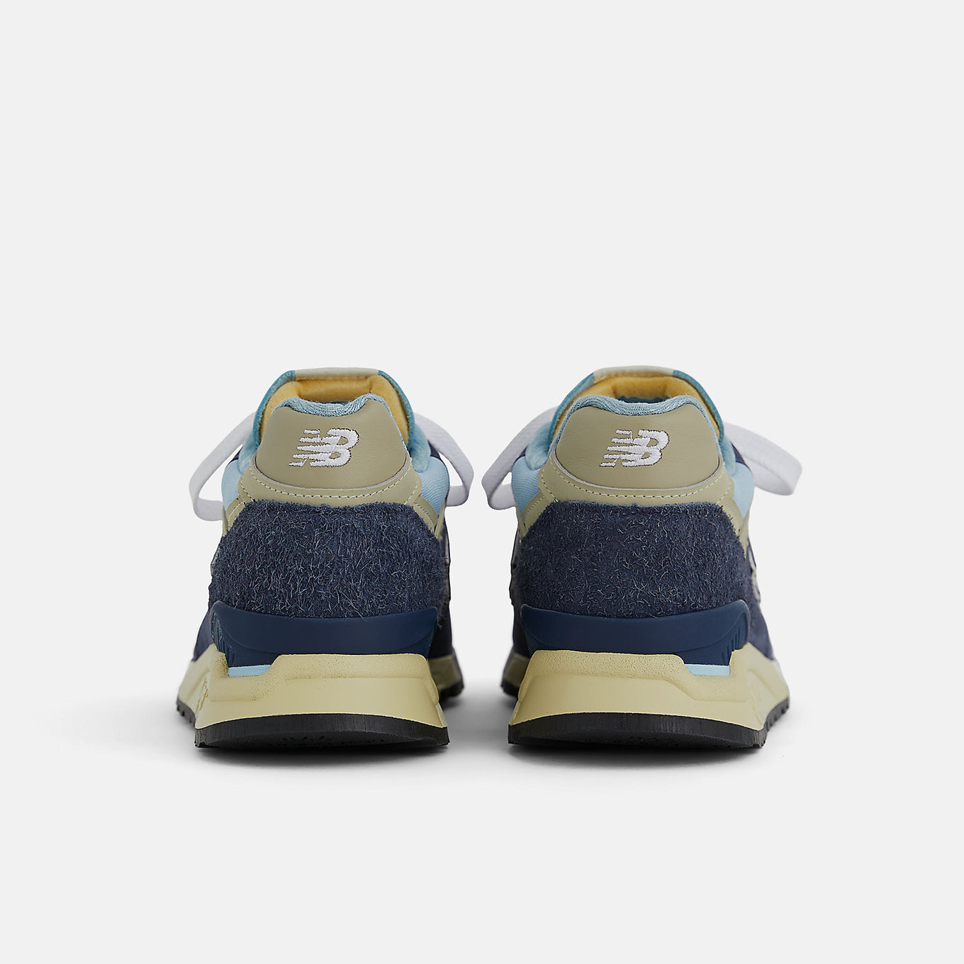 New Balance 998 Made in USA sneakers in navy with chrome blue accents, featuring ABZORB cushioning and premium suede, mesh, and hairy suede construction.