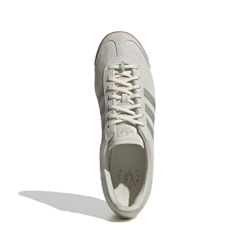 Maha Amsterdam, a prominent women’s streetwear store established in 2015 by Saskia van Hofwegen and Dian Iskandar, collaborates with adidas on the classic sneaker from the late '70s—the adidas Samoa. This design features a low-cut silhouette with a suede upper in "Chalk White," complemented by subtle green accents, comfortable padding, and a cushioned sole. The laces include a jade-colored lace jewel, along with adidas and Maha logo details for added flair.