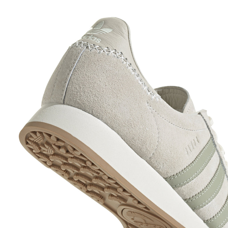 Maha Amsterdam, a prominent women’s streetwear store established in 2015 by Saskia van Hofwegen and Dian Iskandar, collaborates with adidas on the classic sneaker from the late '70s—the adidas Samoa. This design features a low-cut silhouette with a suede upper in "Chalk White," complemented by subtle green accents, comfortable padding, and a cushioned sole. The laces include a jade-colored lace jewel, along with adidas and Maha logo details for added flair.